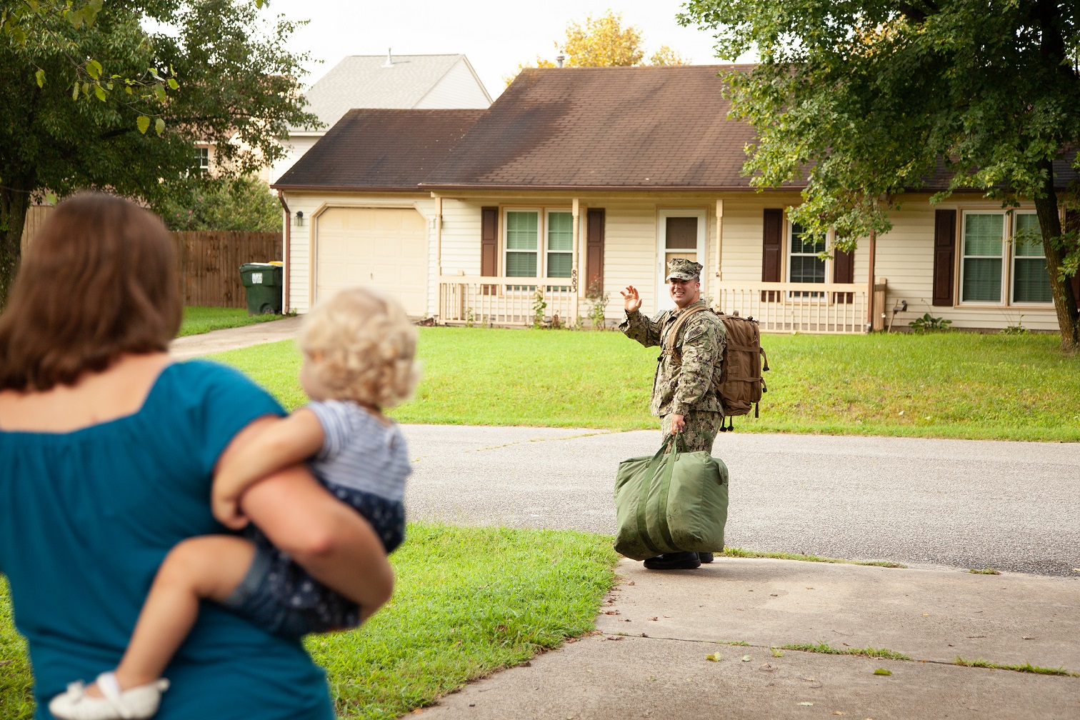 Active navy servicemember waving goodbye to his family